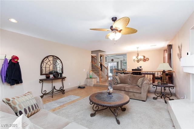 living room with ceiling fan with notable chandelier