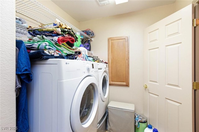 laundry room featuring cabinets and washer and clothes dryer