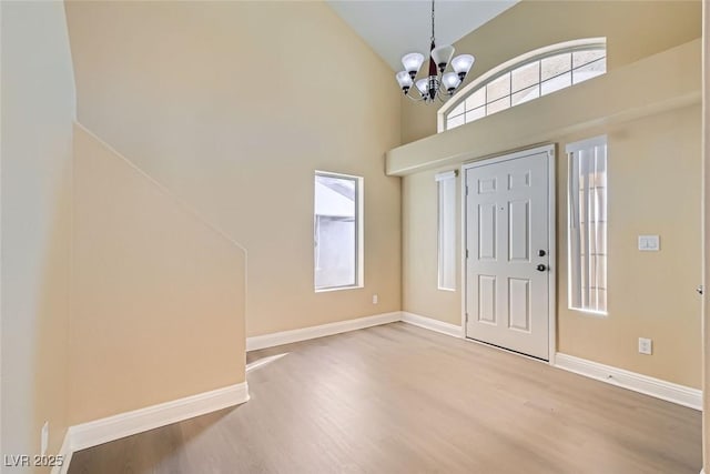 foyer with plenty of natural light, a chandelier, and hardwood / wood-style floors