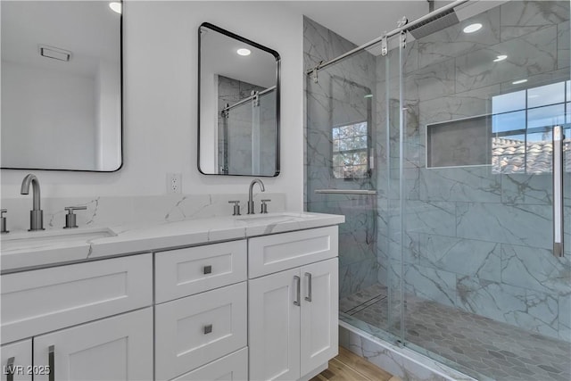 bathroom featuring a healthy amount of sunlight, vanity, a shower with shower door, and wood-type flooring