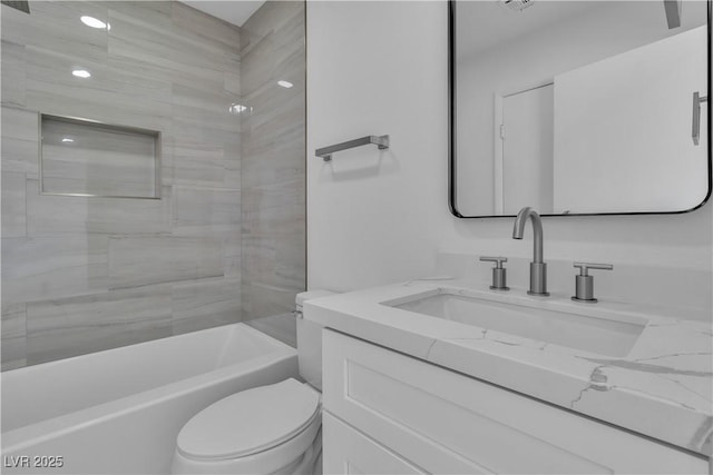 full bathroom featuring vanity, tiled shower / bath, and toilet