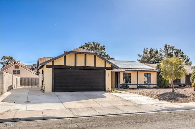 view of front of home featuring roof mounted solar panels, stucco siding, an attached garage, and concrete driveway