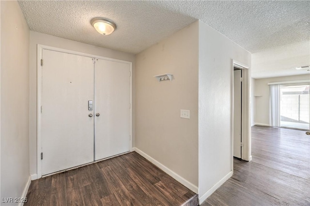 entryway featuring visible vents, baseboards, a textured ceiling, and dark wood-style floors