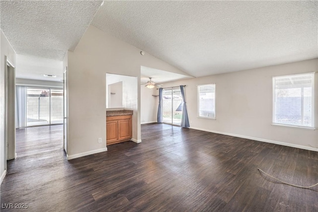 unfurnished living room featuring dark wood-style floors, a healthy amount of sunlight, and lofted ceiling