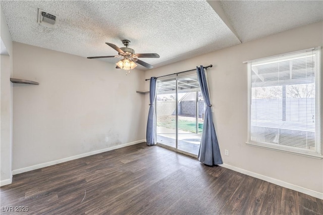 spare room featuring visible vents, a ceiling fan, a textured ceiling, wood finished floors, and baseboards