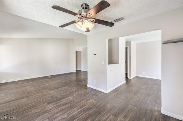 unfurnished room with baseboards, visible vents, ceiling fan, dark wood-type flooring, and a textured ceiling