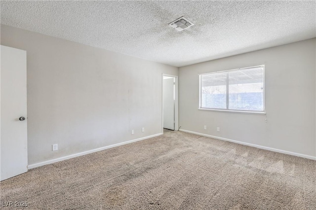 carpeted spare room with visible vents, baseboards, and a textured ceiling