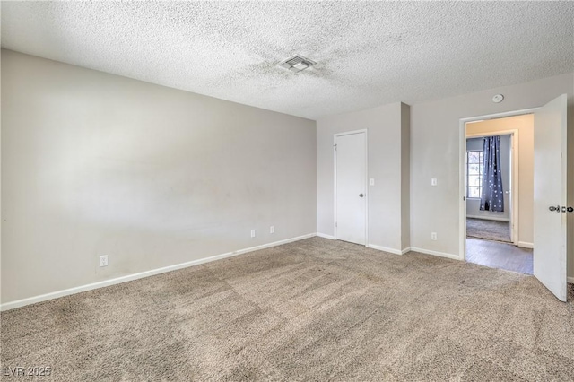 unfurnished bedroom with visible vents, carpet floors, a textured ceiling, and baseboards