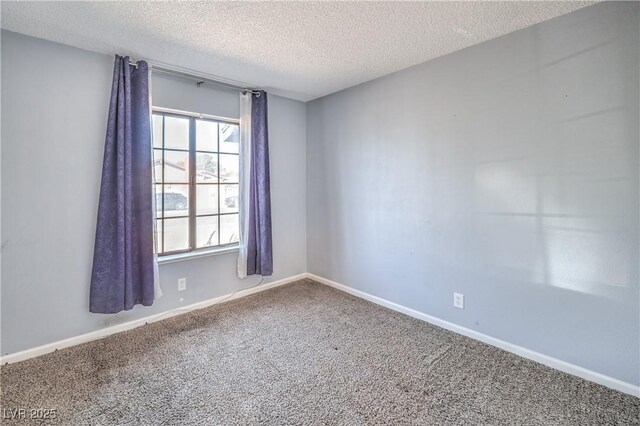 carpeted empty room with a textured ceiling and baseboards