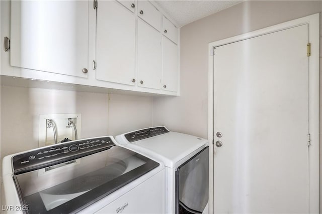 laundry room featuring a textured ceiling, cabinet space, and washer and clothes dryer