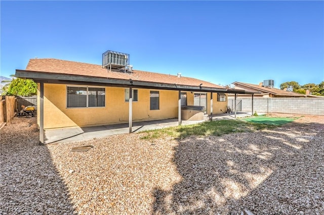 back of house featuring a patio area, central air condition unit, stucco siding, and a fenced backyard