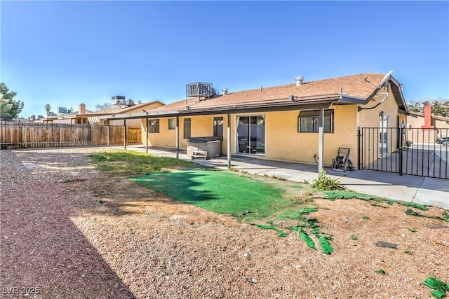 back of property with stucco siding, a patio, and a fenced backyard