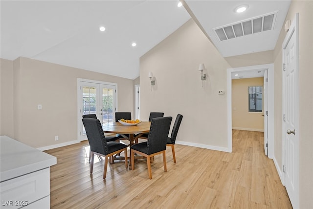 dining room with french doors, high vaulted ceiling, and light wood-type flooring