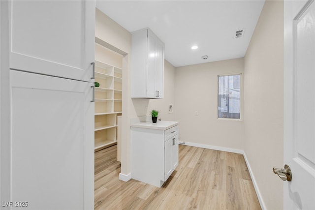 walk in closet with light hardwood / wood-style flooring