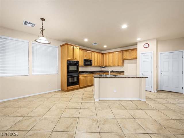 kitchen with light tile patterned flooring, pendant lighting, sink, a kitchen island with sink, and black appliances