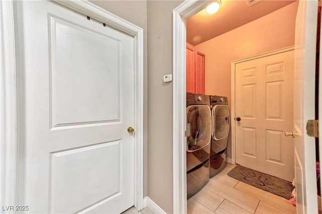 washroom with cabinets and washer and dryer