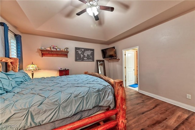 bedroom featuring ceiling fan, dark hardwood / wood-style floors, and a raised ceiling