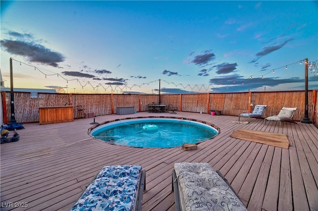 pool at dusk with a deck