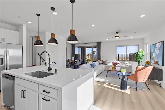 kitchen with white cabinetry, sink, hanging light fixtures, and dishwasher