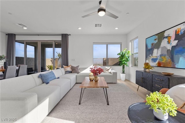 living room with ceiling fan and light hardwood / wood-style flooring