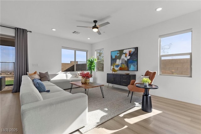 living room with ceiling fan and light wood-type flooring