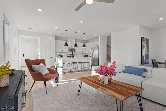 living room featuring ceiling fan and light wood-type flooring