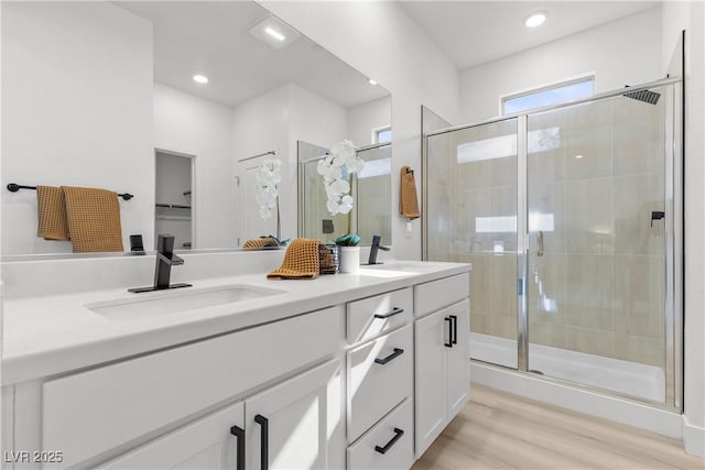 bathroom with hardwood / wood-style flooring, vanity, and an enclosed shower