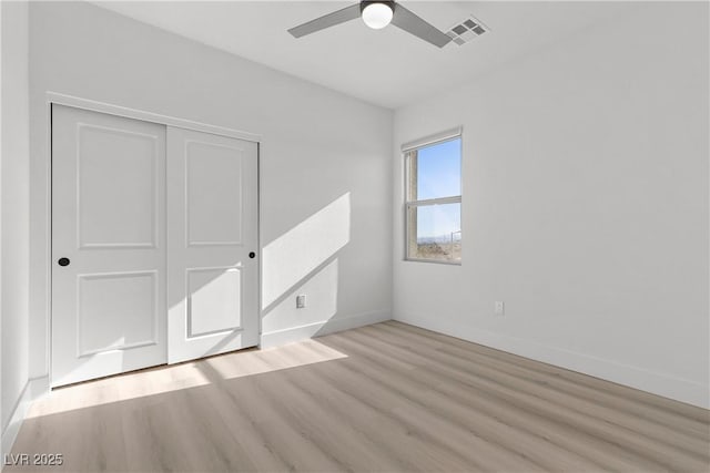 unfurnished bedroom featuring a closet, ceiling fan, and light wood-type flooring