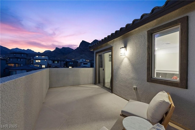 patio terrace at dusk featuring a balcony