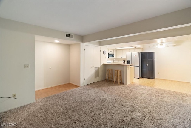 unfurnished living room featuring light colored carpet