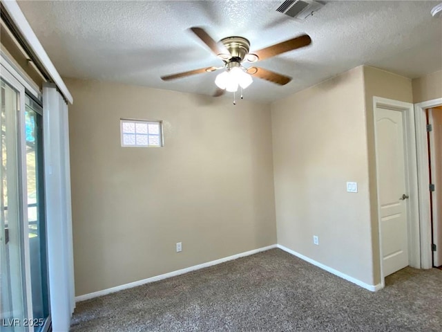 unfurnished room with ceiling fan, carpet floors, and a textured ceiling