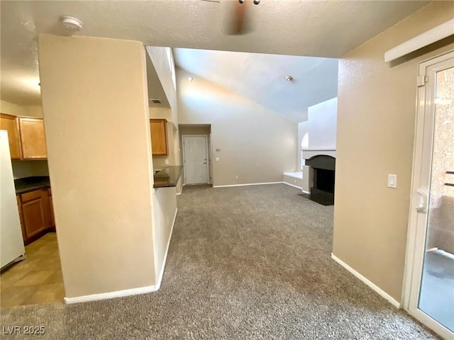 unfurnished living room with lofted ceiling, a textured ceiling, and carpet flooring