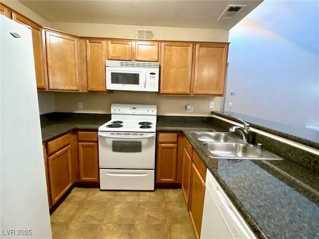 kitchen featuring white appliances, sink, and light tile patterned floors