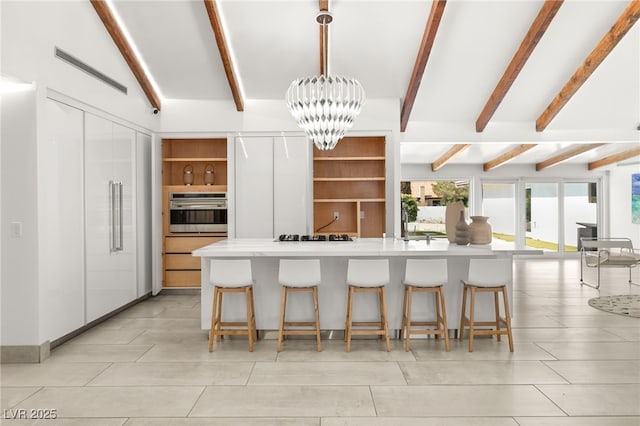 kitchen featuring beam ceiling, a kitchen breakfast bar, a notable chandelier, decorative light fixtures, and oven