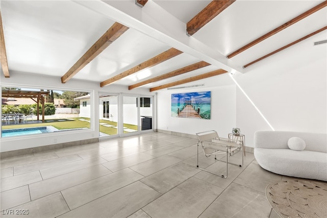 unfurnished living room with beamed ceiling