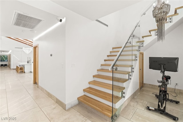 stairway with tile patterned flooring and a chandelier