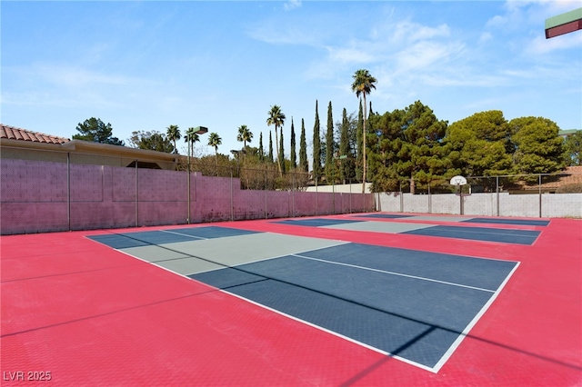 view of tennis court featuring basketball hoop