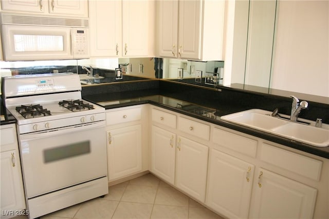 kitchen featuring white appliances, light tile patterned floors, sink, and white cabinets