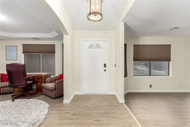 entryway with a textured ceiling and light hardwood / wood-style floors