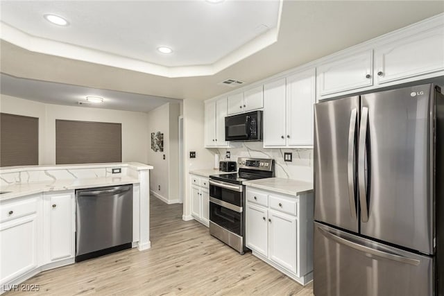 kitchen featuring white cabinetry, stainless steel appliances, and light stone countertops