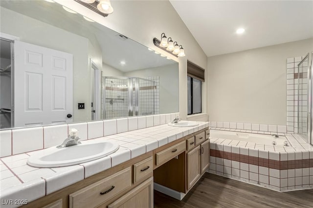 bathroom featuring hardwood / wood-style flooring, vanity, separate shower and tub, and lofted ceiling