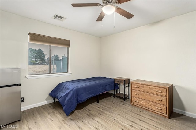 bedroom with ceiling fan, stainless steel refrigerator, and light hardwood / wood-style floors