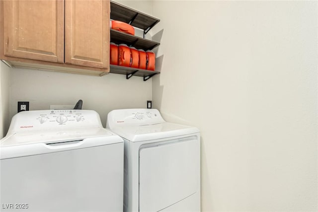 washroom with cabinets and washing machine and clothes dryer