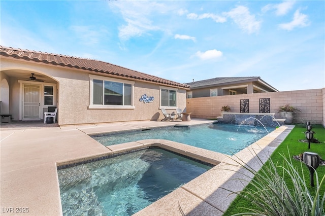 rear view of property featuring a swimming pool with hot tub, a patio, and ceiling fan