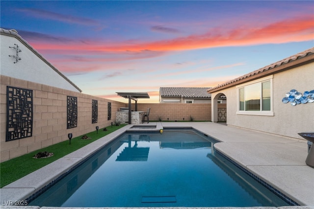 pool at dusk with a patio area