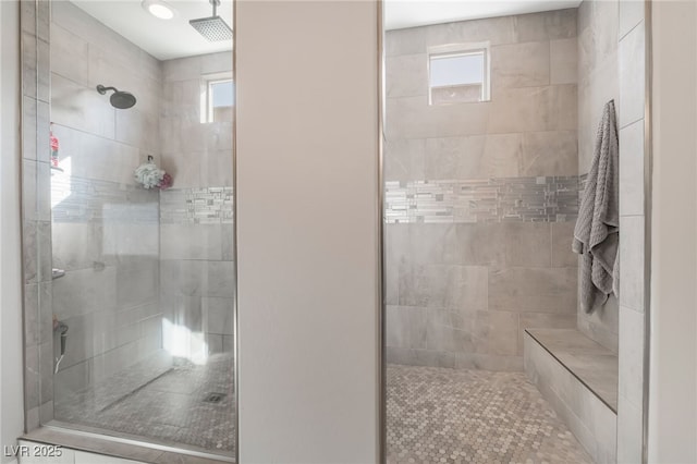 bathroom featuring tiled shower and a wealth of natural light