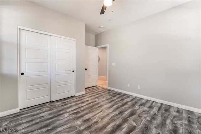 unfurnished bedroom with dark hardwood / wood-style floors, a closet, and ceiling fan