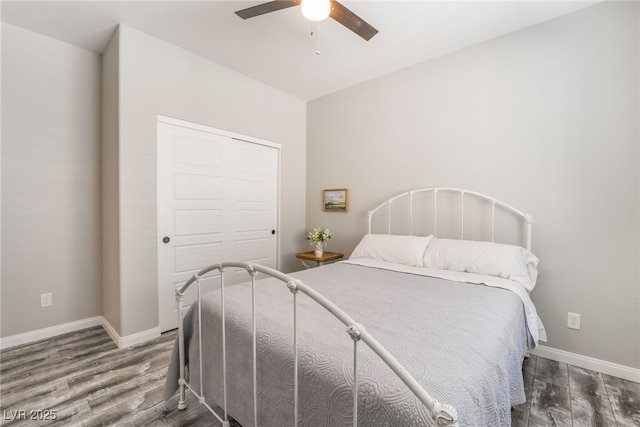 bedroom with dark hardwood / wood-style floors, ceiling fan, and a closet