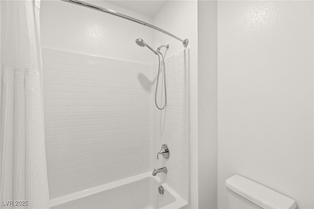 bathroom featuring shower / tub combo and toilet