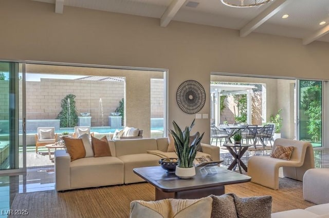 living area featuring beamed ceiling and recessed lighting